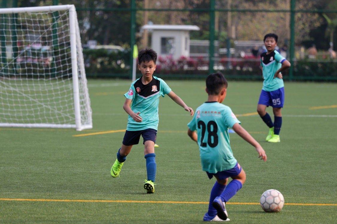 Jeunes footballeurs en match sur un terrain synthétique
