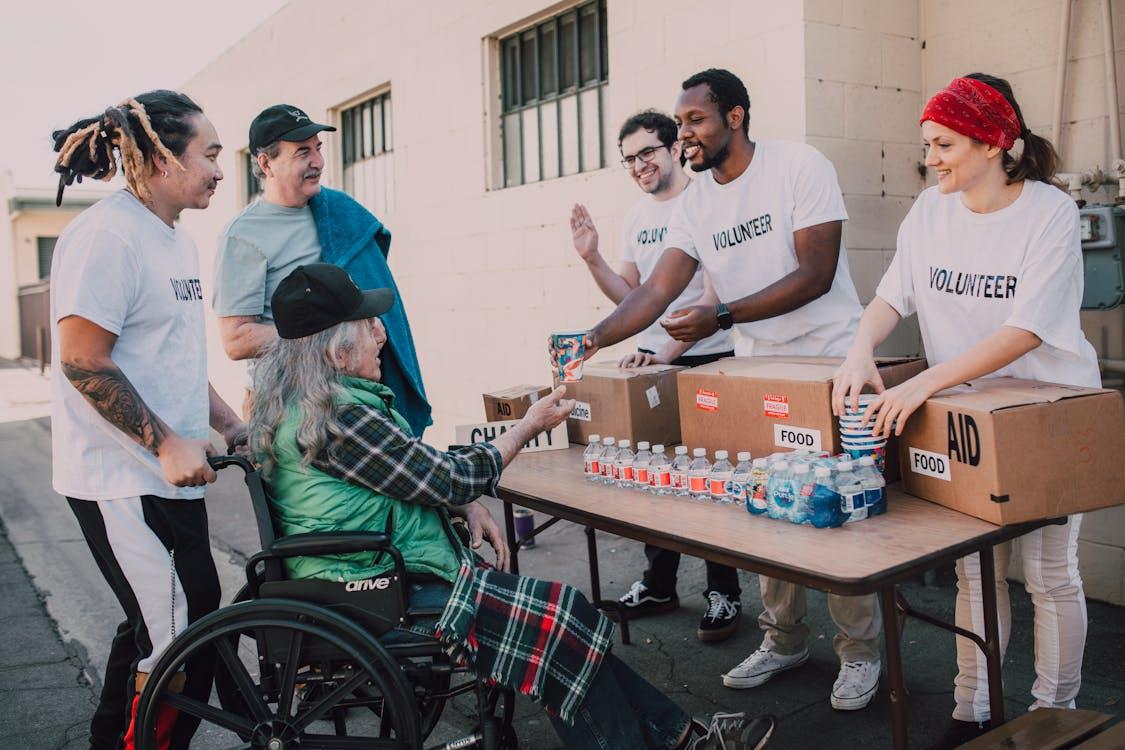 Bénévoles aidant une personne en fauteuil roulant, solidarité et mécénat associatif