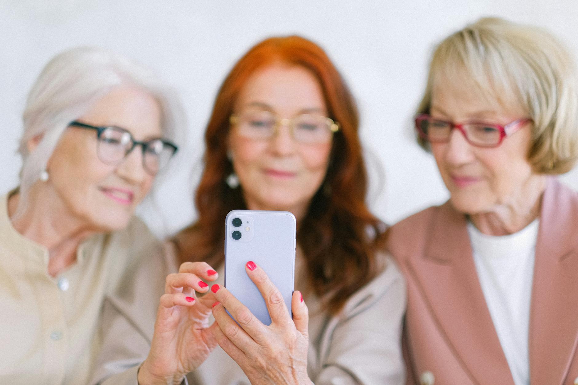 Trois adhérentes consultent ensemble une application sur smartphone