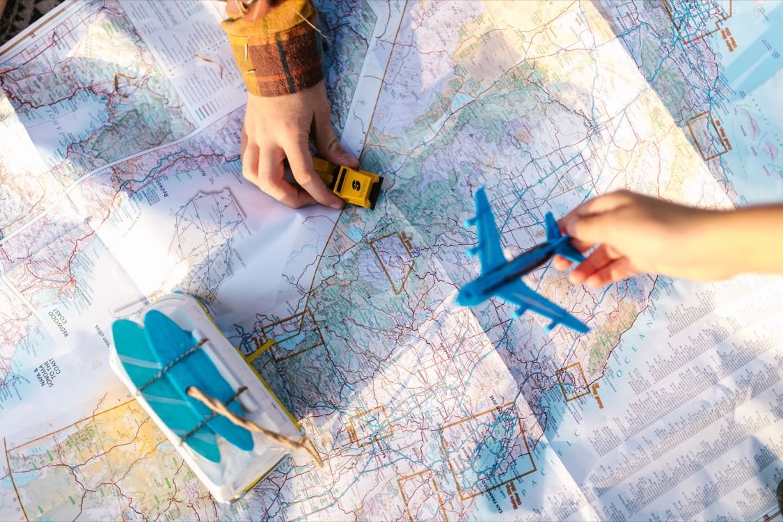Petits véhicules jouets posés sur une carte routière dépliée